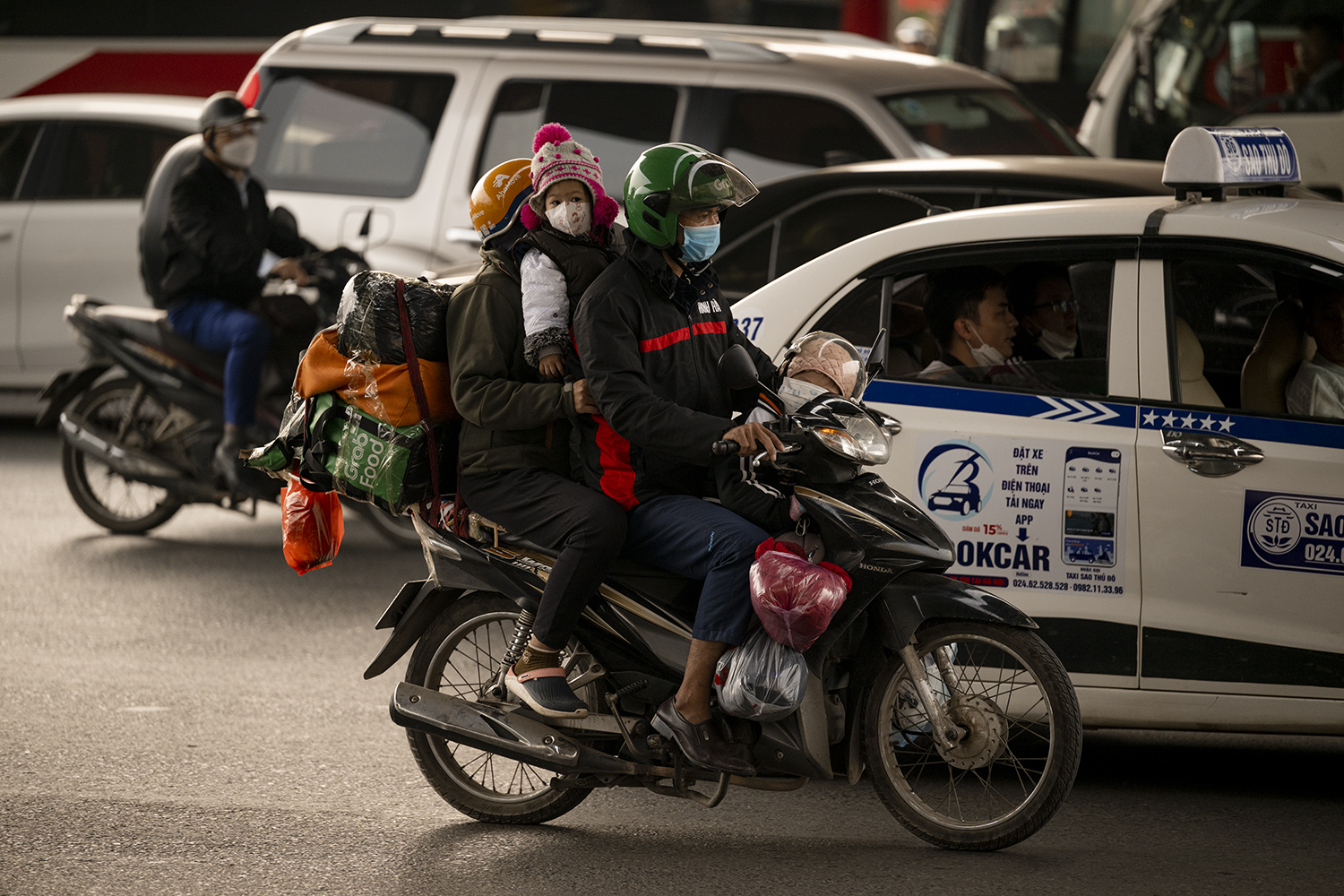 Những em nhỏ cùng gia đình quay lại Hà Nội bằng xe máy sau Tết.