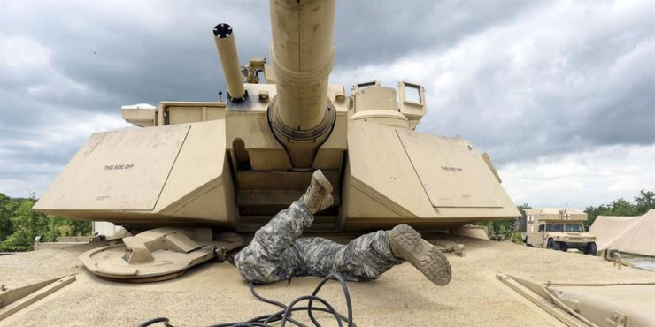 Binh sĩ Mỹ trườn vào khoang lái của xe tăng M1A1 Abrams tại căn cứ quân sự Fort Benning thuộc bang Georgia (Mỹ) tháng 5-2016. Ảnh: US ARMY