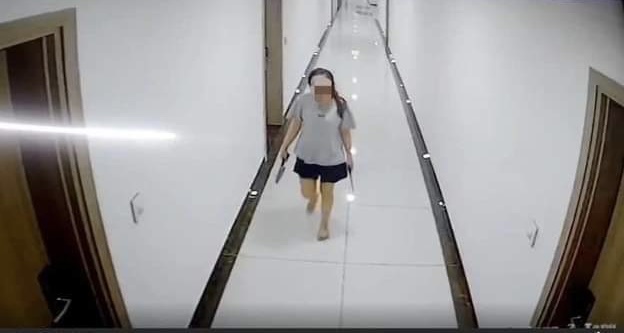 Bà Y. cầm dao đi dọc hành lang (hình ảnh trích xuất từ camera an ninh)