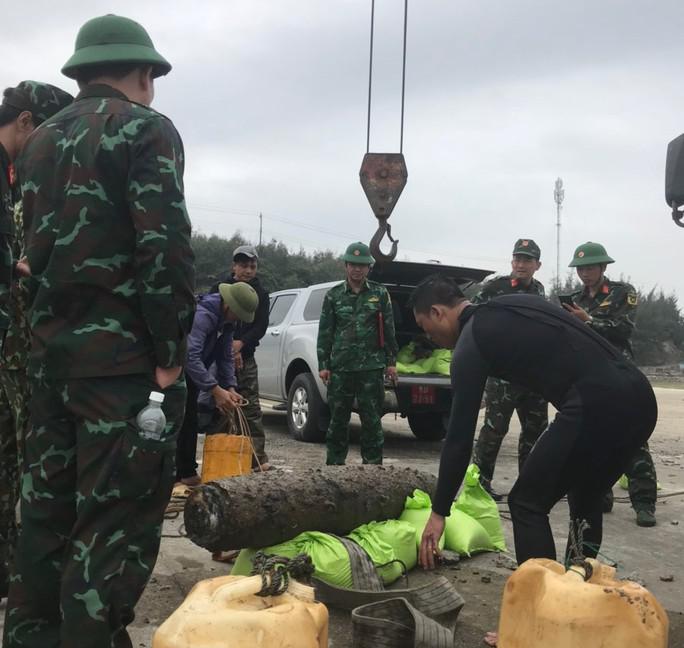 Lực lượng chức năng đưa quả bom lên bờ để vận chuyển đi tiêu hủy