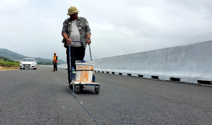 Các công nhân đang kẻ chỉ để phân làn đường. Dải phân cách của tuyến cao tốc Nha Trang - Cam Lâm được được thi công cao 1,2 m để chống chói.