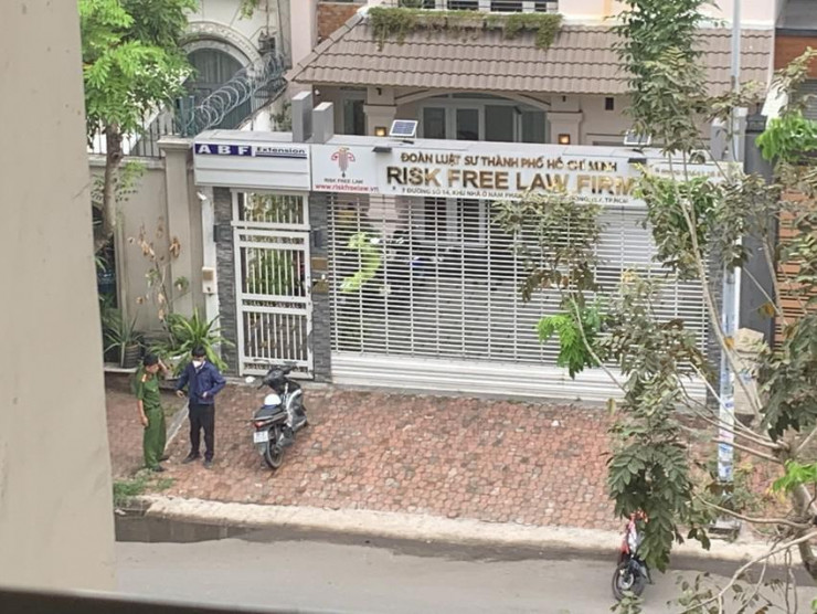 Công an túc trực bên ngoài trong khi việc khám xét đang được thực hiện bên trong căn nhà ở phường Tân Thuận Đông, quận 7. Ảnh: HT