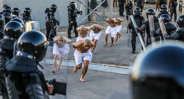 Các tù nhân chạy bộ vào cơ sở giam giữ mới ở El Salvador.