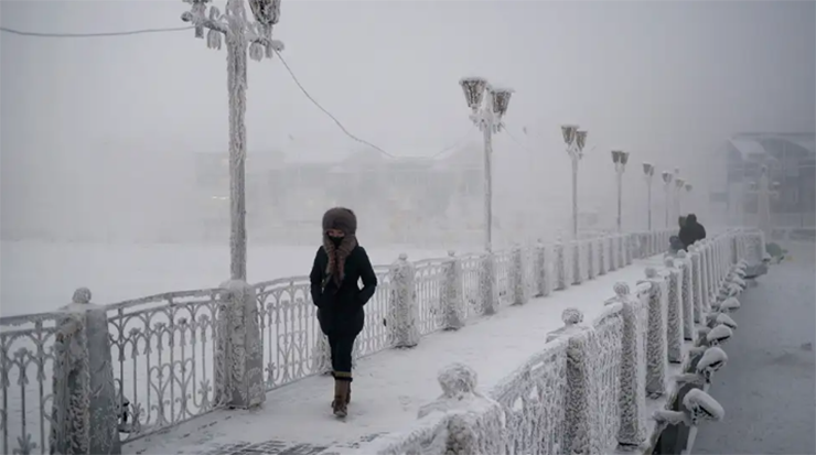 Một người phụ nữ đi qua cây cầu dày đặc băng tuyết ở Yakutsk.
