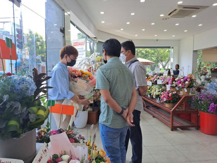 Nhân viên cửa hàng hoa đang giới thiệu cho khách các sản phẩm hoa cho ngày 8-3. Ảnh: Thu Hà