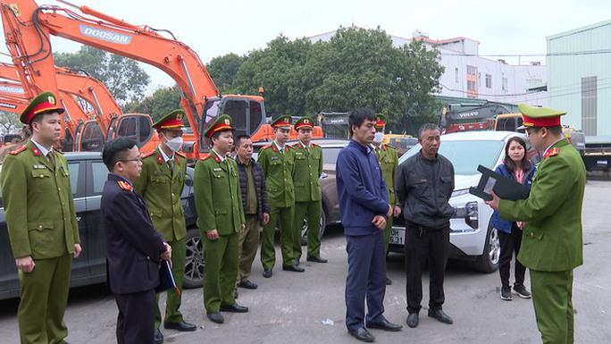 Công an huyện Đông Anh tống đạt các quyết định tố tụng đối với lãnh đạo, nhân viên Trung tâm Đăng kiểm xe cơ giới 29-07D. Ảnh: Công an cung cấp