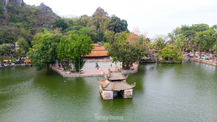 Màu hoa nở đỏ rực trên nền núi trập trùng tạo nên một khung cảnh tĩnh mịch, cổ kính của chùa Thầy.