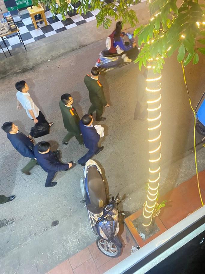 Ông Nguyễn Đình Đương (áo xanh, tay cầm vải trắng) bị cơ quan công an bắt giữ tối 13-3
