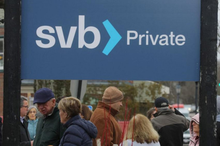 Khách hàng xếp hàng chờ bên ngoài một chi nhánh của Ngân hàng Silicon Valley Bank ở TP Wellesley, bang Massachusetts (Mỹ) ngày 13-3. Ảnh: REUTERS