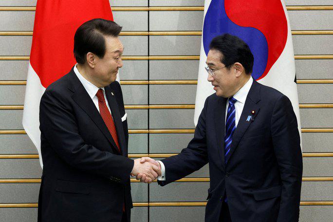 Tổng thống Hàn Quốc Yoon Suk-yeol (trái) bắt tay Thủ tướng Nhật Bản Kishida Fumio trong cuộc gặp hôm 16-3 Ảnh: REUTERS