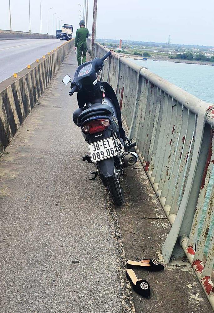 Chiếc xe máy trên cầu, bên cạnh là đôi dép nghi của người nhảy cầu tự tử
