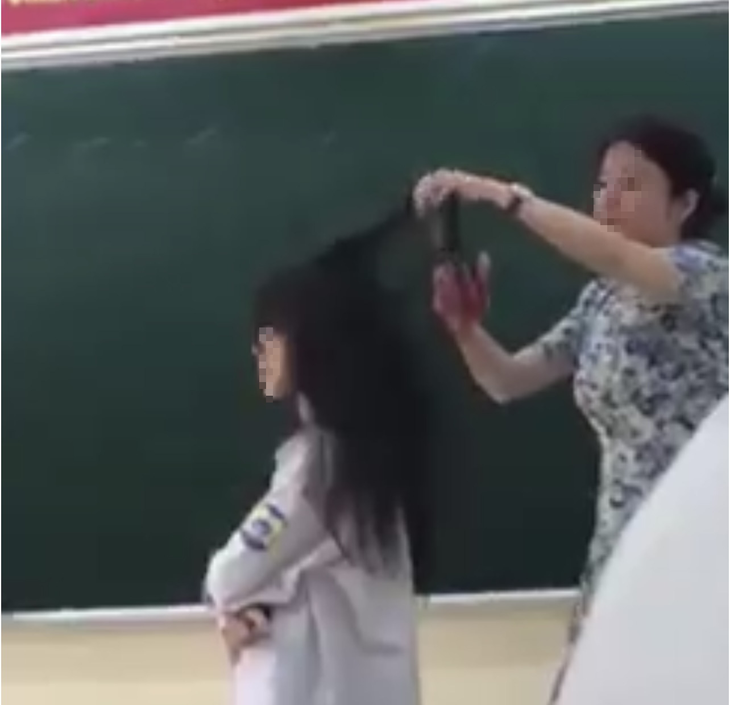 Hình ảnh cô giáo cắt tóc học sinh trong lớp học. (Ảnh cắt từ clip).