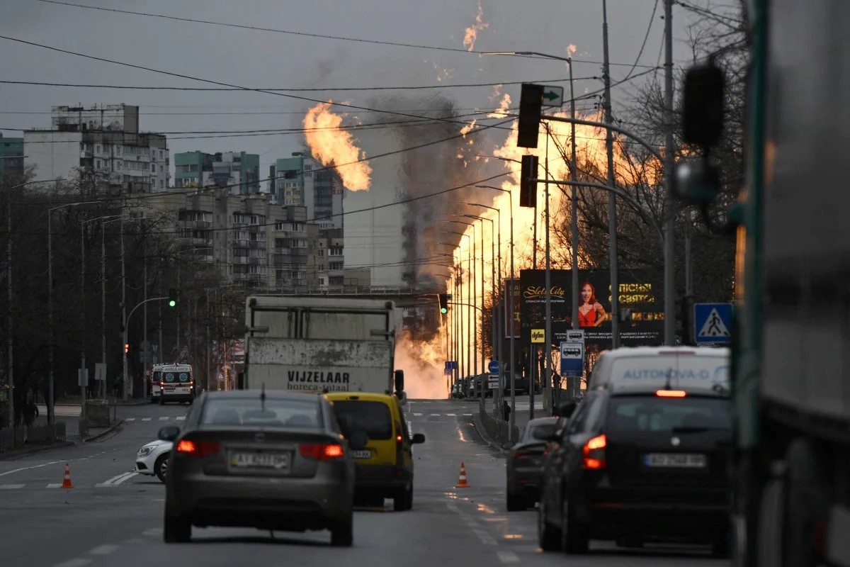 Xe ô tô di chuyển qua một đám cháy trên đường phố Kiev (ảnh: Reuters)