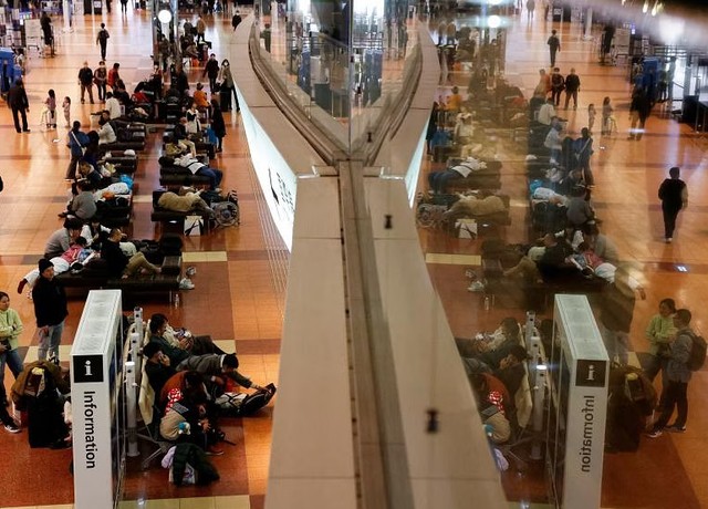 Hành khách kẹt lại sau khi sân bay Haneda phong tỏa tất cả đường băng. Ảnh: Reuters