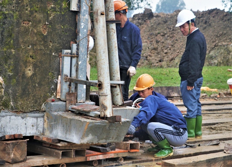 Nhiều ngày qua, “thần đèn” Nguyễn Văn Cư (mũ trắng) trực tiếp có mặt, chỉ đạo việc di dời cổng đền để đảm bảo nguyên trạng cho công trình sau di dời. "Cổng đền nặng khoảng 100 tấn, không phải là lớn nhưng do đã cũ, kết cấu vữa yếu nên rất phức tạp khi di dời. Việc di chuyển đến vị trí mới cách 63m nên cần cẩn thận, tỉ mỉ từng công đoạn”, ông Cư cho hay.