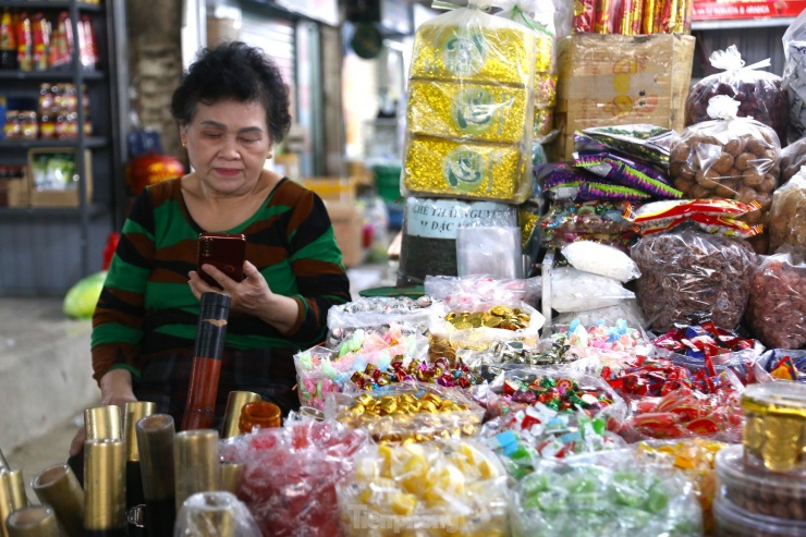 Vắng khách, nhiều tiểu thương ngồi lướt điện thoại giết thời gian.