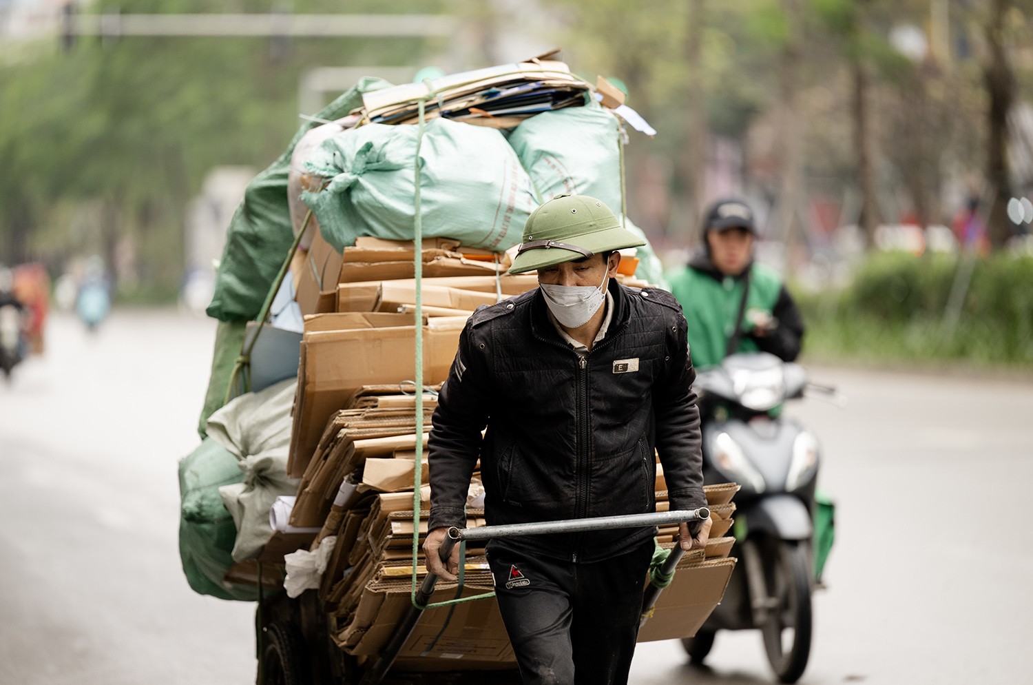 &nbsp;Dưới cái lạnh thấu xương, người đàn ông này&nbsp;oằn&nbsp;mình kéo một chiếc xe đầy hàng trên phố Xã Đàn.