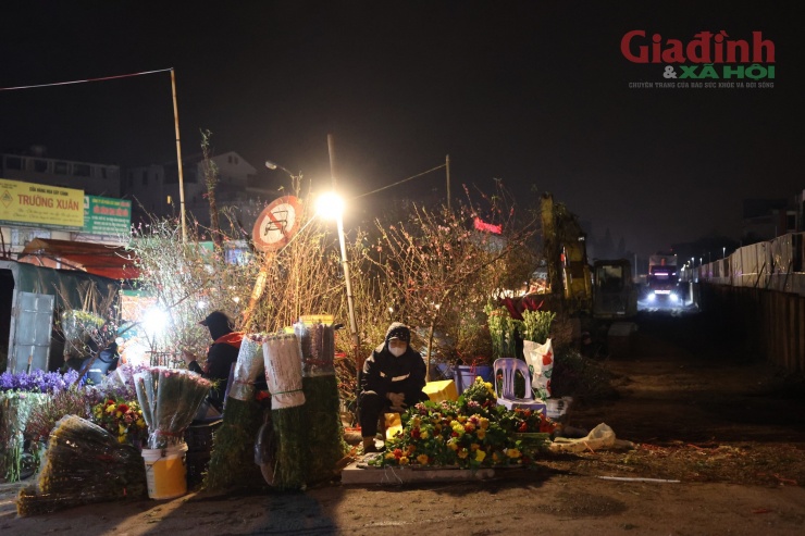 Tại cổng chợ hoa Quảng An, vì không có khách nên tiểu thương "đội" sương, gió ngồi chờ khách xuyên đêm.