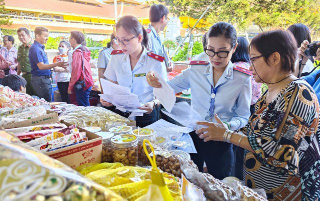 Cán bộ an toàn thực phẩm kiểm tra nguồn gốc hàng hóa tại chợ Bình Tây (quận 6, TP HCM). Ảnh: NGỌC ÁNH