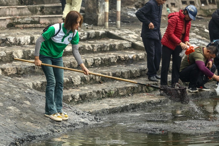 Công nhân môi trường có mặt từ sáng sớm, liên tục phải đi vớt rác, tro, chân hương cùng với cá vàng chết nổi lên mặt hồ.