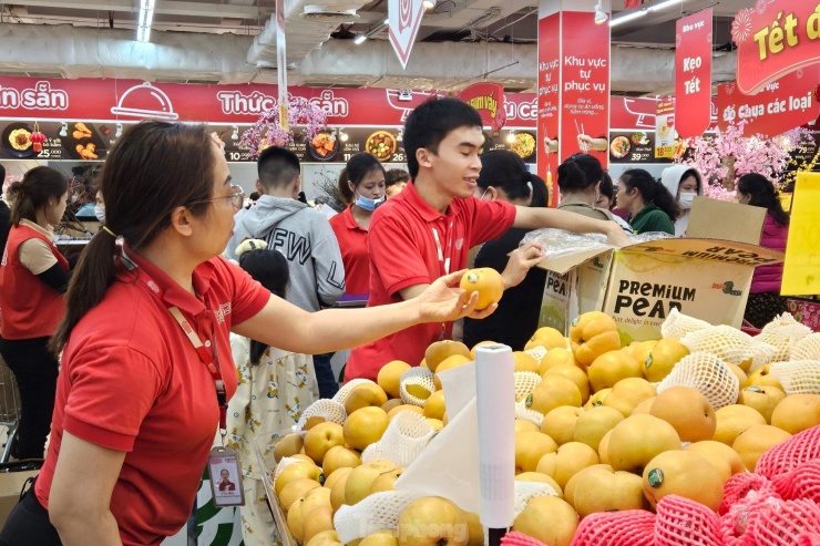 Nhân viên siêu thị liên tục bổ sung hàng hóa lên kệ hàng đáp ứng nhu cầu mua sắm của người tiêu dùng trước Tết Nguyên Đán.