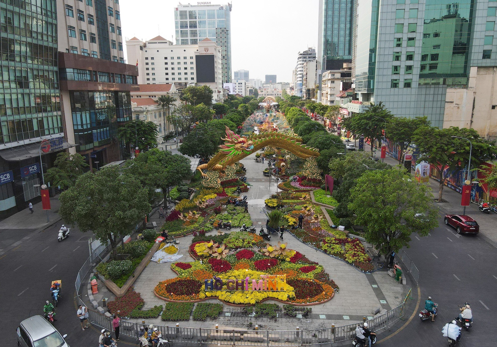 Trước giờ mở cửa, xung quanh đường hoa được rào chắn và bảo vệ. Nhiều người dân, du khách tìm đến nhìn ngắm, chụp hình đường hoa, “bầy rồng” từ bên ngoài vào.