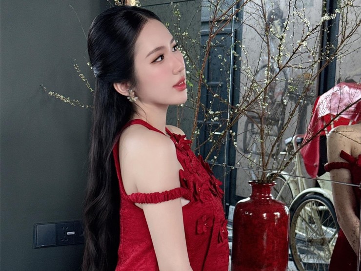 Hot girl Sài thành Nguyễn Hồng Ngọc lựa chọn thiết kế áo dài dáng yếm kín đáo hơn với tông màu đỏ.
