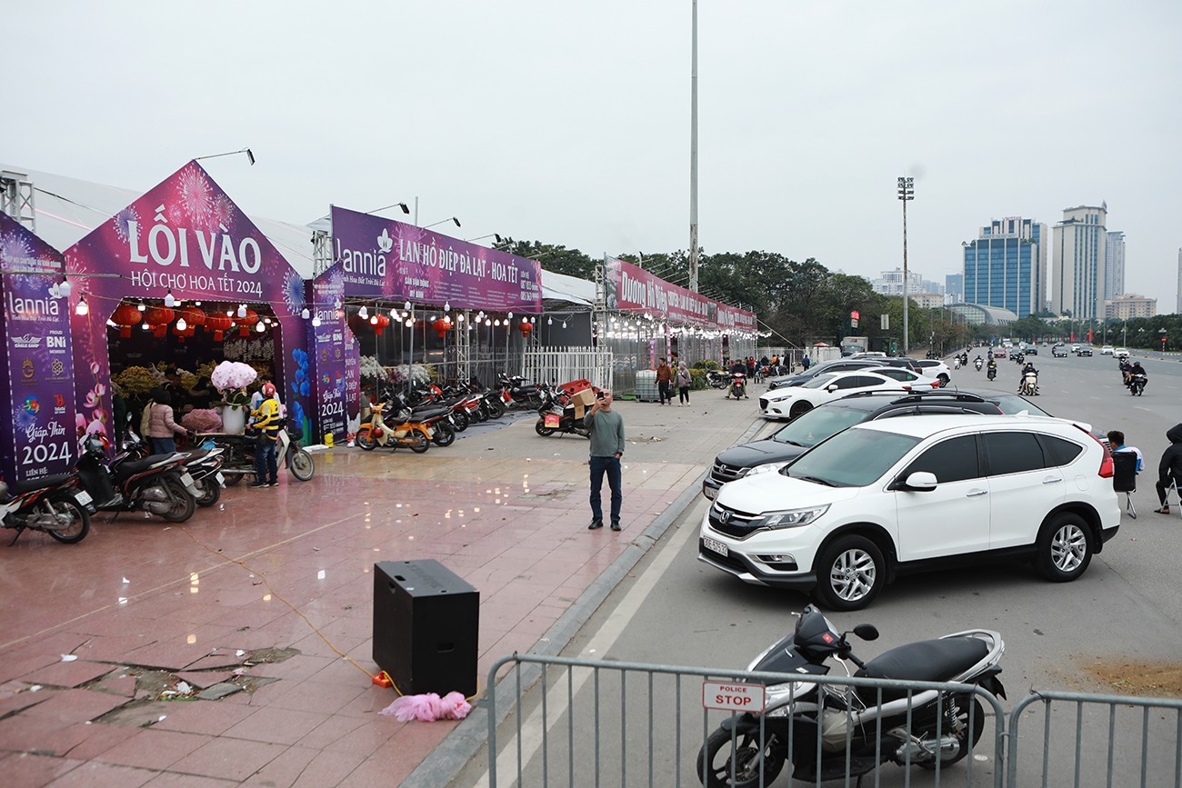 Những cửa hàng&nbsp;bán hoa lan Đà Lạt ngay cạnh sân Mỹ Đình cũng nhộn nhịp, người dân đỗ ô tô kín mặt trước cửa hàng.