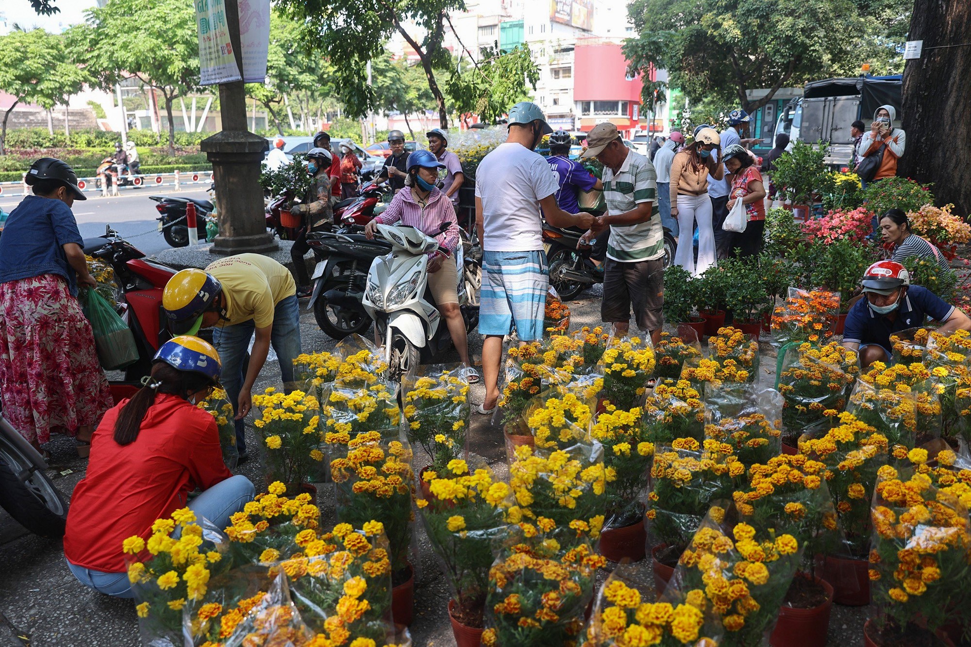 Cảnh mua bán khẩn trương ở nhiều khu vực chợ hoa vào thời điểm gần trưa khi các tiểu thương chuẩn bị hoàn trả mặt bằng trước 12h ngày 30 Tết.