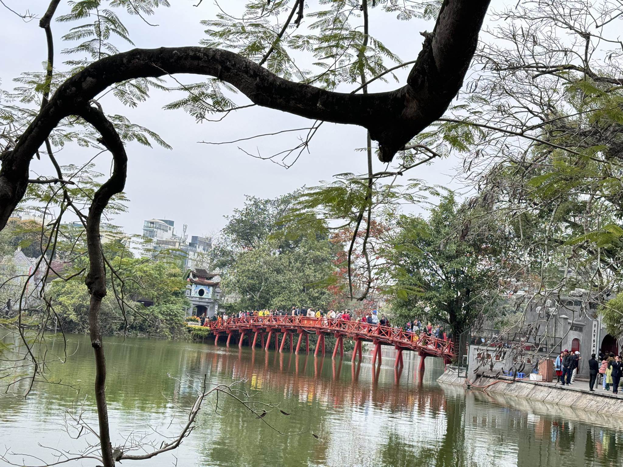 Cầu Thê Húc luôn chật cứng người. Thời tiết Hà Nội chiều mùng 2 Tết nắng ấm, thích hợp để mọi người đi du xuân.