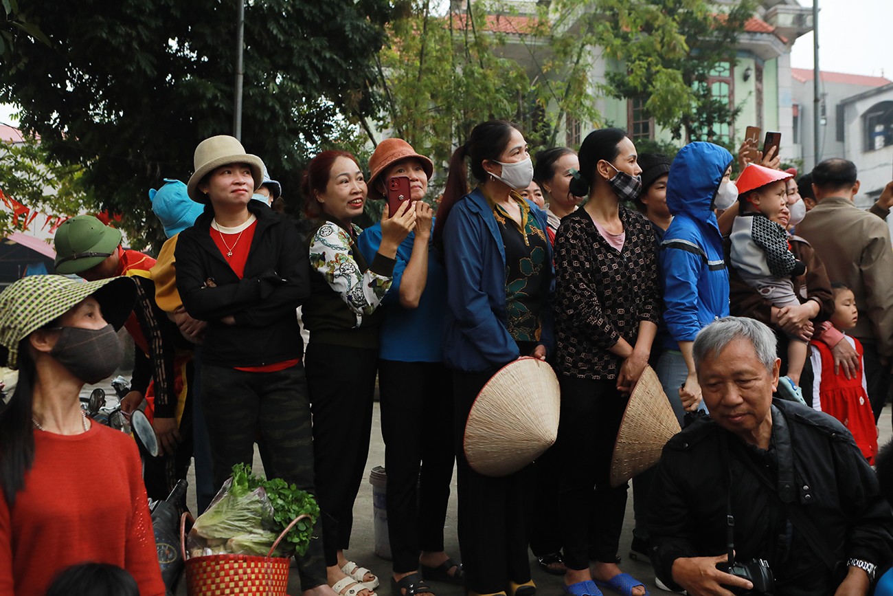 Nhiều người đi xe dọc theo mương nước, đối diện đoàn rước để theo xem toàn cảnh lễ hội.