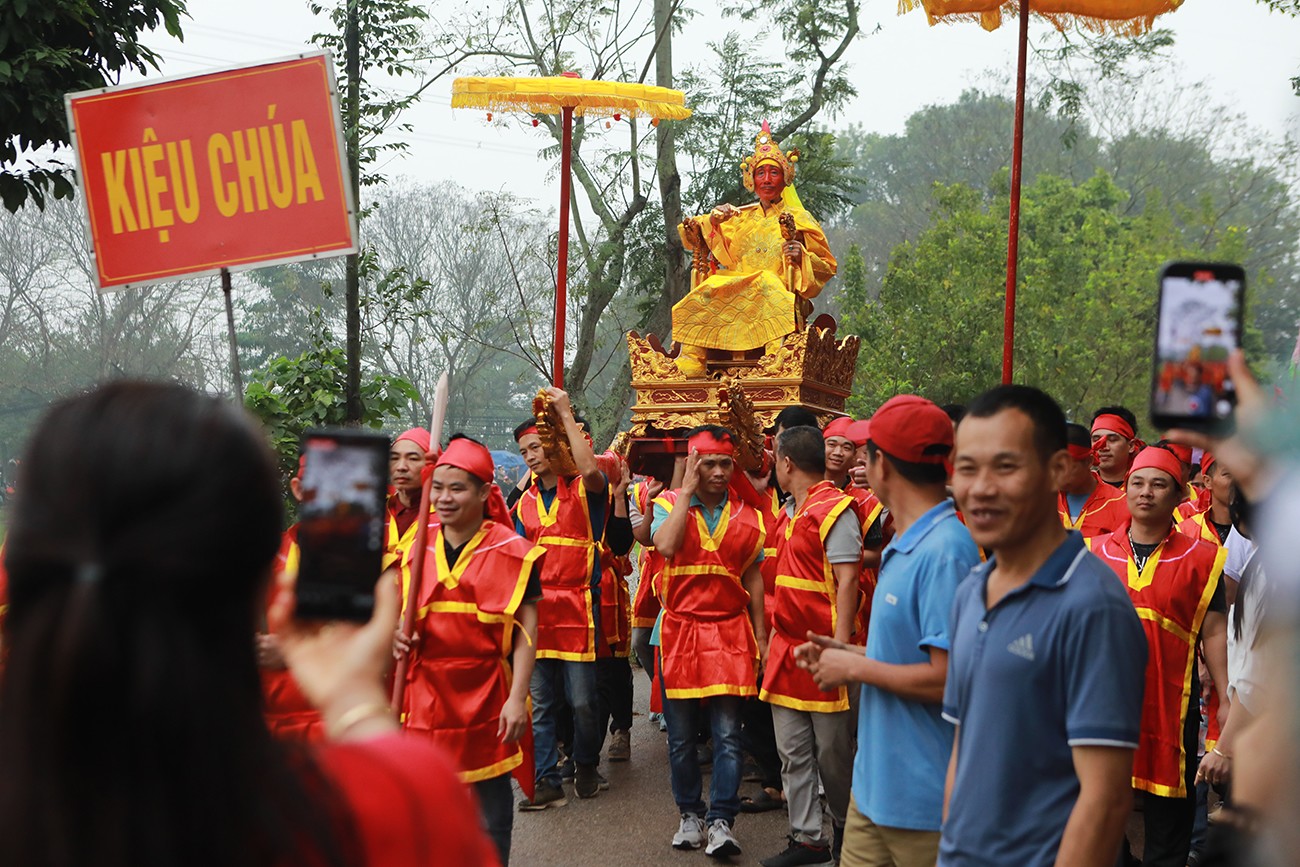 Du khách và người dân đứng kín hai bên đường làng đi theo đoàn rước, reo hò tưng bừng, chụp ảnh và thi nhau livestream hình ảnh “Vua, Chúa sống”.