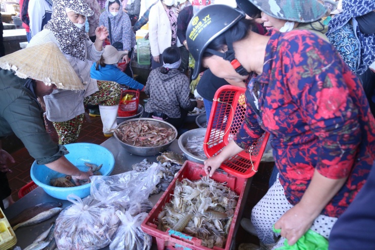 Phía trên bờ, tiểu thương cùng người dân ngã giá mua bán. Tiếng trao đổi, cười nói rôm rả vang khắp cả bến cảng.