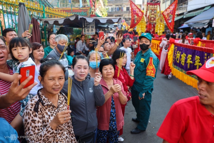 Người dân hai bên đường đổ xô ra chào mừng đoàn rước. Nhiều người cầm theo nhang, chắp tay cầu nguyện khi tượng Quan Công đi ngang qua.