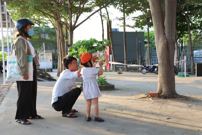 Ba mẹ hướng dẫn con phóng sinh những chú chim khỏi lồng.