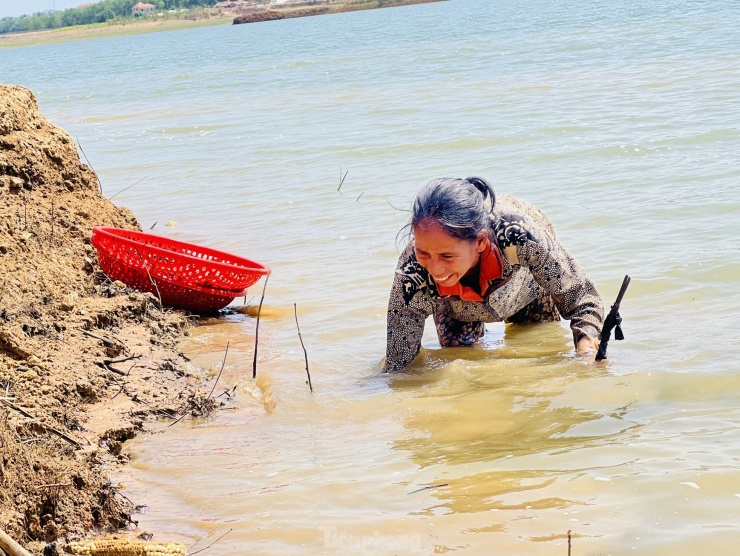 Dù nắng nóng hơn 34oC, họ vẫn vui vẻ cặm cụi vừa cào, vừa đãi hến để kiếm thêm thu nhập.