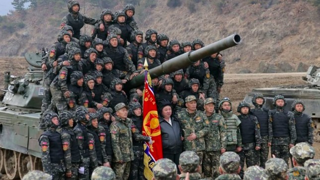 Nhà lãnh đạo Triều Tiên chụp ảnh cùng các sĩ quan và binh lính trước một chiếc xe tăng. (Ảnh: KCNA)