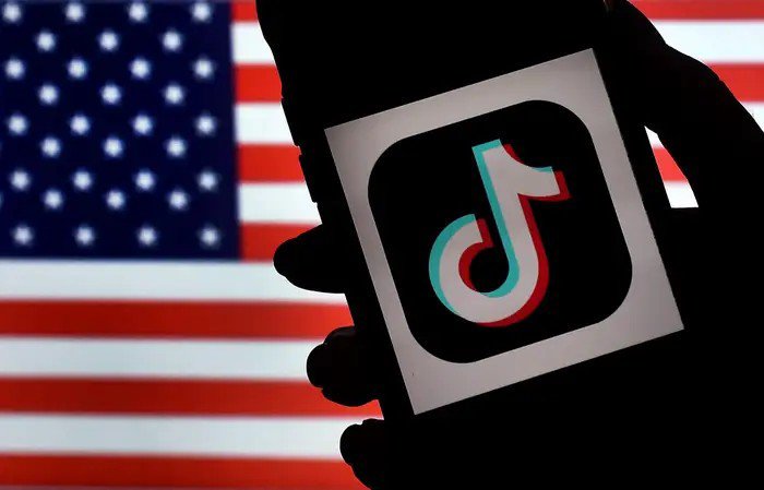 Logo ứng dụng TikTok đặt trước cờ Mỹ. Ảnh: AFP