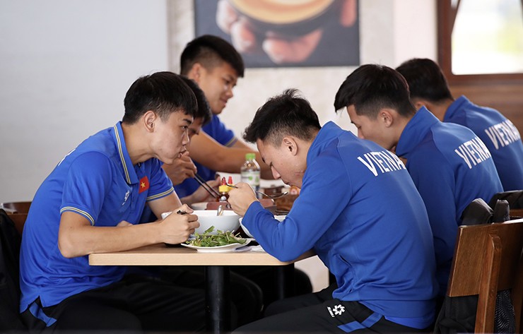 Đình Bắc và một số tuyển thủ Việt Nam tranh thủ ăn sáng ở sân bay Nội Bài.
