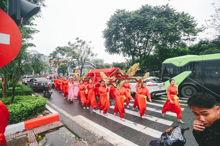 Đoàn rước kiệu "bay" trên đường Cổ Linh (quận Long Biên, Hà Nội), nơi có nhiều phương tiện lưu thông. Ô tô phải dừng giữa đường để "nhường" cho đoàn rước.