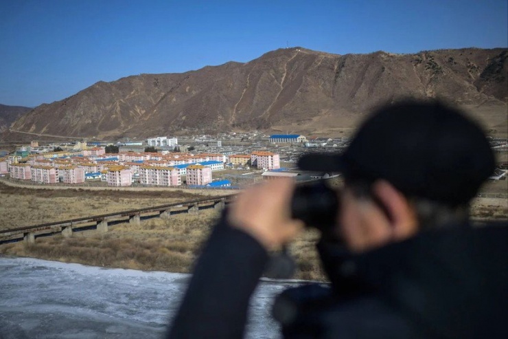 Một người sử dụng ống nhòm để nhìn từ tỉnh Cát Lâm (đông bắc Trung Quốc) về phía TP Namyang (Triều Tiên). Ảnh: AFP