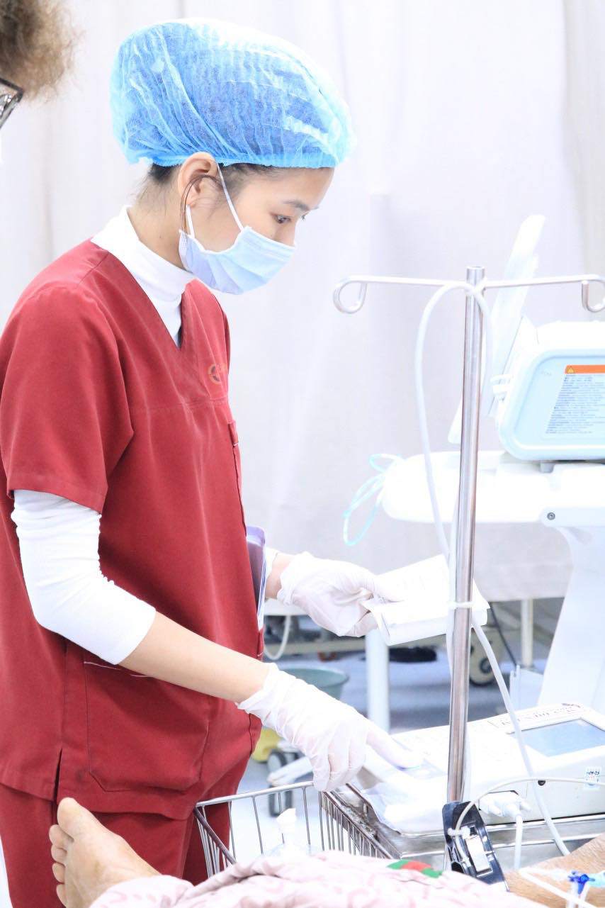 Điều dưỡng viên Đặng Thị Hạ chăm sóc cho một bệnh nhân tại bệnh viện.