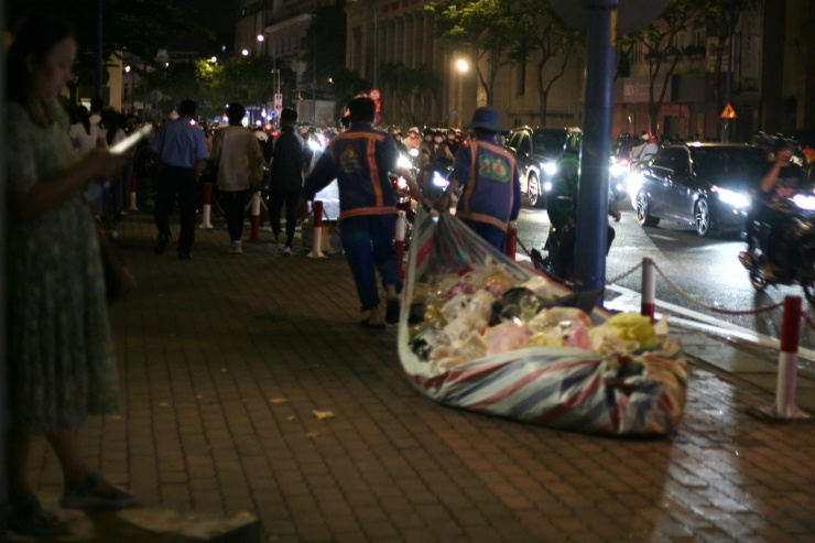 "Lượng rác năm nay nhiều hơn các năm trước. Nguyên nhân chính là do các cửa hàng trong khu vực và những xe hàng rong thu hút đông người dân. Đặc biệt, pháo giấy từ màn pháo hoa của một đơn vị tổ chức chương trình khuyến mãi rơi đầy đường bám vào đồ ăn, thức uống bị đổ xuống đất khiến việc quét dọn tốn thời gian hơn. Công việc dù vất vả, chúng tôi vẫn quyết tâm sẽ hoàn thành sớm để trả lại sự sạch đẹp cho thành phố vào sáng sớm ngày đầu năm" - một nhân viên Công ty TNHH MTV Dịch vụ Công ích quận 1 chia sẻ.