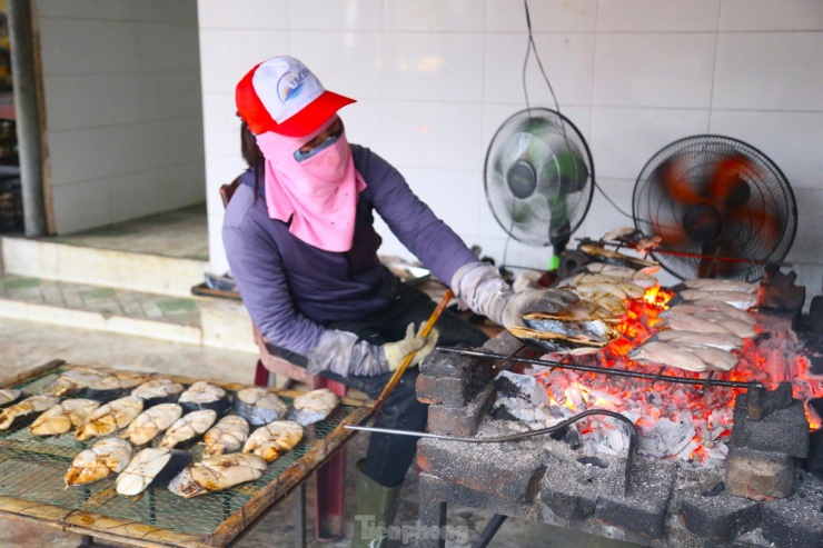 Người nướng cá phải điều chỉnh nhiệt độ, lửa phù hợp bằng cách gạt than và lật đều tay để cá chín đều hai mặt.