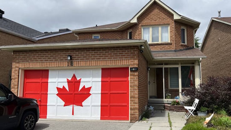 Người dân Canada sơn lá cờ quốc gia ở garage phía trước nhà vào ngày 30/6/2024. Ảnh: Nur Photo.