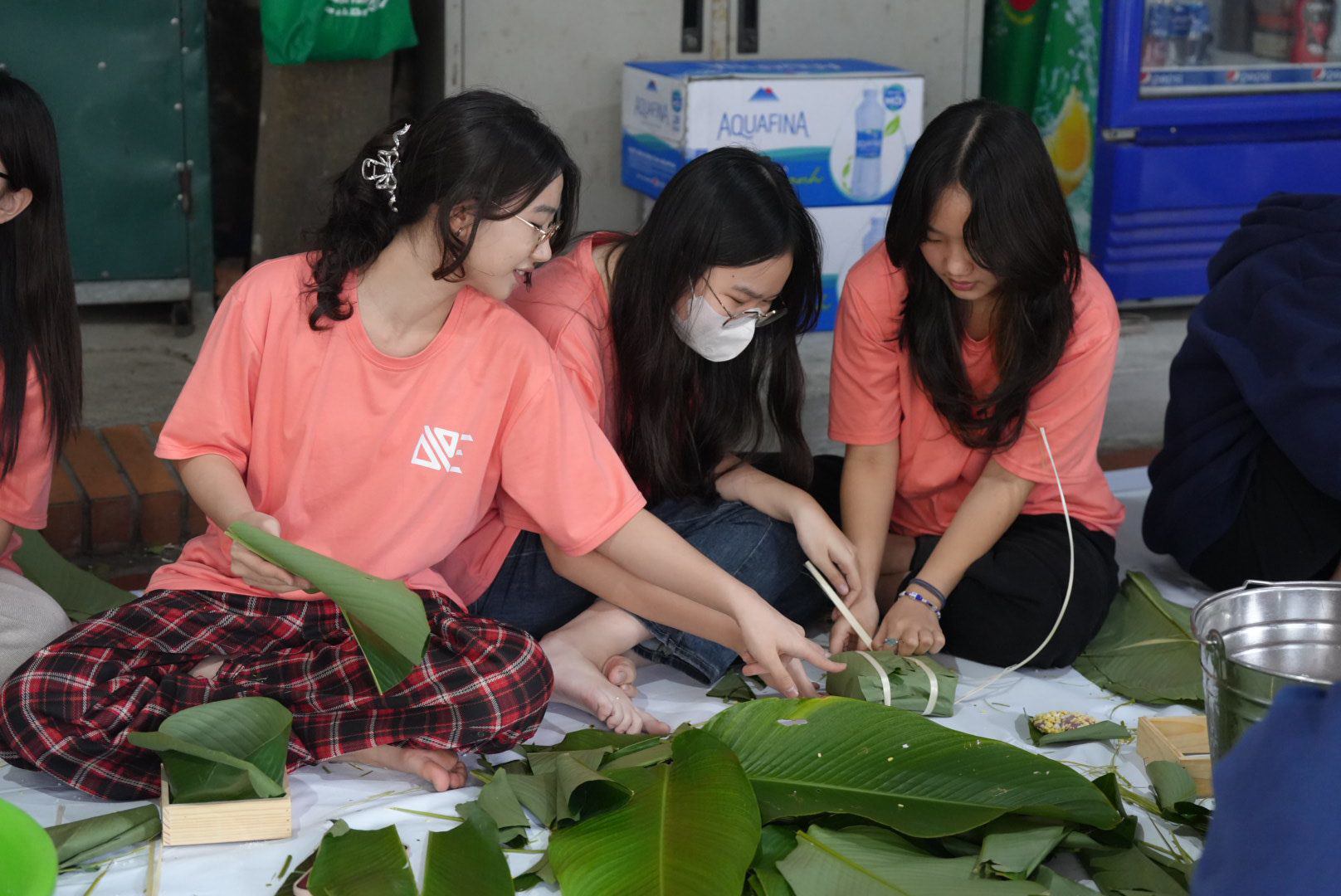 Dạy trẻ gói bánh chưng trong ngày Tết.