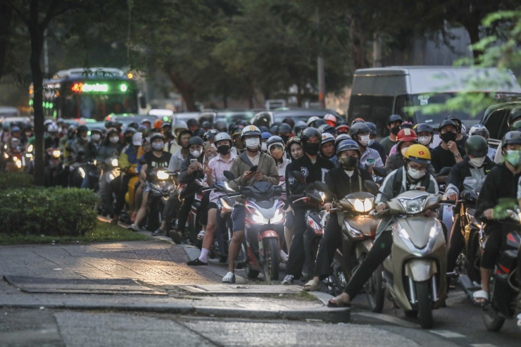 Đường Nguyễn Bỉnh Khiêm (quận 1) đông đúc vào giờ tan tầm. Đoàn người nối đuôi nhau di chuyển ở dưới đường chứ không leo lên vỉa hè như trước đây.