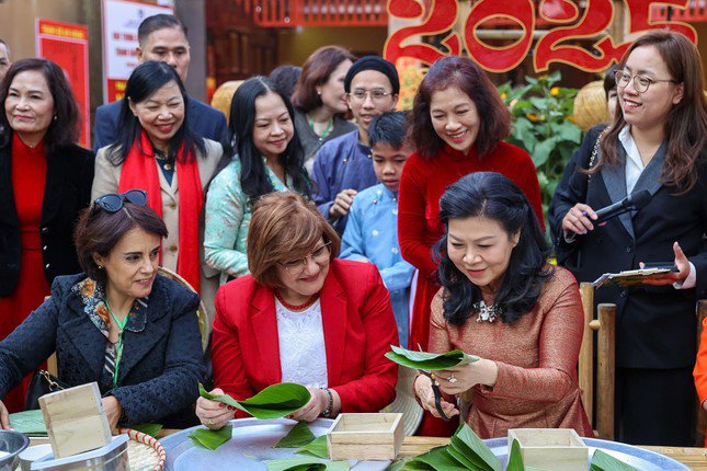 Bà Ngô Phương Ly - Phu nhân Tổng Bí thư Tô Lâm, hướng dẫn các nữ đại sứ, phu nhân đại sứ cách gói bánh chưng. (Ảnh: Mofa)