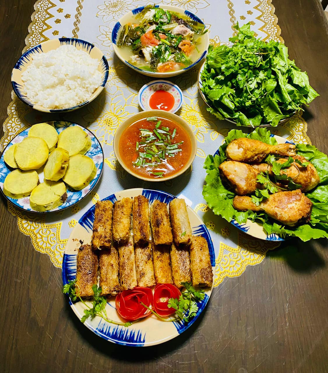 Nem rán, đùi gà chiên, canh dưa nấu cá, rau sống, khoai lang luộc.