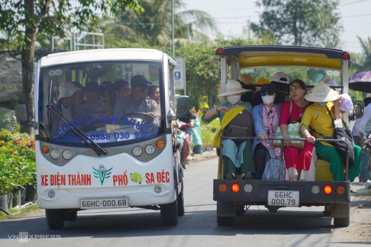 Xe điện chở du khách đi tham quan, nhiều người chọn trang phục truyền thống như áo dài, áo bà ba cho chuyến du xuân.